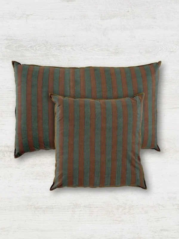 funda-de-cojin-bayadere-azul-petroleo-y-terracota-sobre-madera-gris